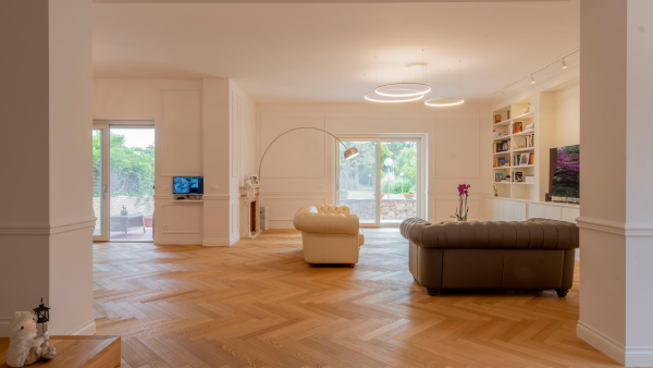 Sala con pavimento in parquet a spina di pesce nella zona living