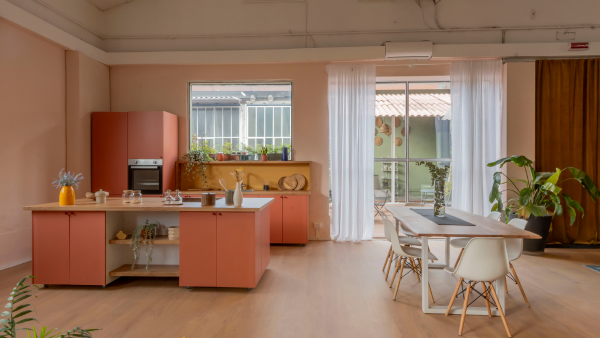 La cucina a isola del loft con le ante rosa