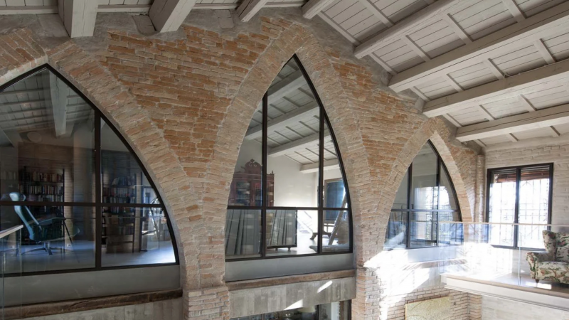 Finestre ad arco in ferro e mattoni a vista